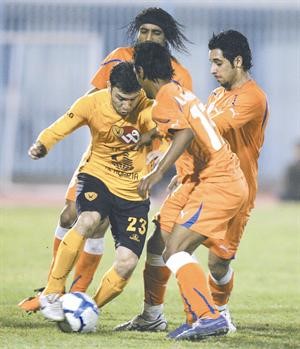 جهاد الحسين محاصر بين ثلاثة من لاعبي كاظمة	الازرق كوم﻿