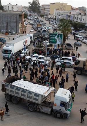 ﻿ليبيون يتجمعون حول شاحنة تحتوي على مساعدات في بنغازي﻿