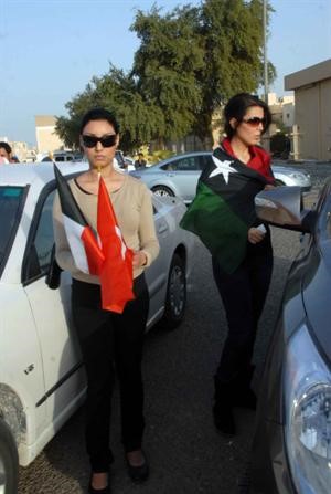 العلمان الكويتي والليبي في ايدي متظاهرتين﻿
