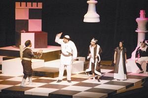 مشهد من مسرحية صائد الاحلام وفي الاطار شعار مهرجان الخرافي المسرحي﻿