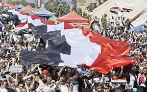 معارضون للرئيس يحملون علما يمنيا ضخما خلال مظاهرة لهم في صنعاء امس	 اپ﻿