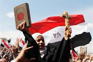 فتاة مصرية مسلمة ترفع في يديها القران الكريم والصليب خلال جمعة الوحدة الوطنية في ميدان التحرير امس	رويترز
﻿
