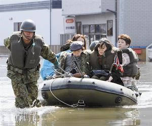 جندي ياباني يساهم في اجلاء مدنيين بواسطة قارب مطاطي في مقاطعة مياجي﻿