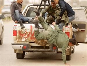 احد الثوار الليبيين يسقط من السيارة خلال هربهم من احدى المناطق في بنغازي									افپ﻿