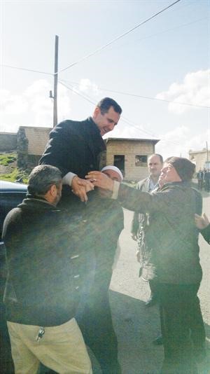 احد المواطنين يحمل الرئيس بشار الاسد خلال زيارته المفاجئه للسويداء