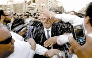 محتجون يرشون دمحمد البرادعي بالماء لدى ادلائه بصوته امس 			افپ
﻿