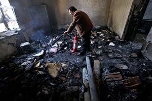 مواطن يطفئ النيران في احدى قاعات المحكمة التي احرقت في مواجهات امس الاول في درعا	اپ﻿