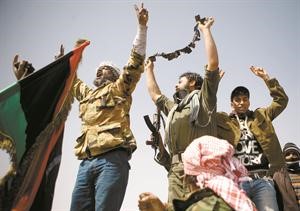 ثوار ليبيون يلوحون بـتعويذة وحصلوا عليها من احد المرتزقة المقاتلين مع قوات القذافي في بن جواد اپ