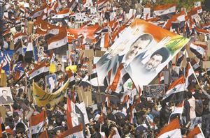 حشود المؤيدين ترفع صورة الامين العام لحزب الله الى جانب صورة الرئيس بشار الاسد في مسيرة دمشق امس افپ
