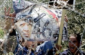 فلسطينيون يرفعون صورة ياسر عرفات خلال مظاهرة يوم الارضافپ