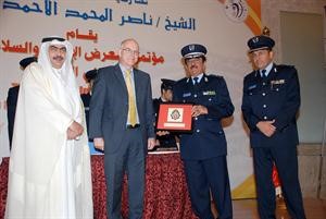 الوزير روضان الروضان واللواء المنصوري خلال تكريم احد المشاركين في المؤتمر﻿