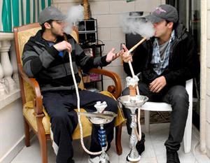 شابان يدخنان الشيشة في احد مقاهي بيروت﻿