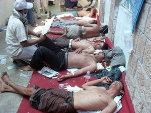 مسعفون يحاولون انقاذ عدد من المصابين في هجوم الامن على المتظاهرين في تعز