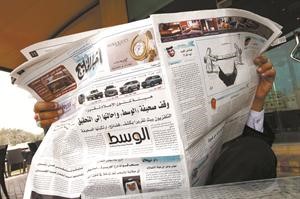 بحريني يقرا في اخبار الخليج التي يظهر على صدر صفحتها الاولى خبر عن ايقاف المنامة لصحيفة الوسط رويترز