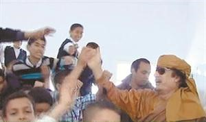صورة عن التلفزيون الليبي للعقيد معمر القذافي لدى زيارته مدرسة جيل الوحدة في زنتان اف پ 