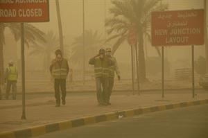 عمال اسيويون يتقون الغبار باستخدام الكمامات
