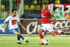لاعب الاهلي محمد شوقي يحاول تسديد الكرة بمواجهة لاعب الشرطة