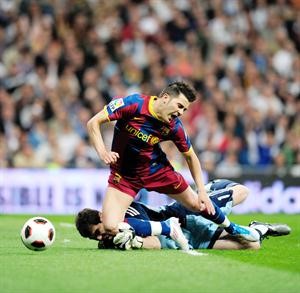 مهاجم برشلونة دافيد فيا يتعرض للعرقلة من حارس مرمى ريال مدريد ايكر كاسياس 