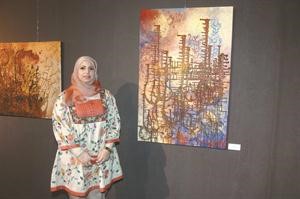 الفنانة ديمة القريني بجانب احد اعمالها﻿