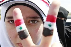 فتاة سورية ترفع اشارة النصر خلال مظاهرة امام السفارة السورية في عمان	رويترز﻿