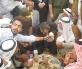 عصام شرف ياكل بيديه مع بدو سيناء على الارض﻿