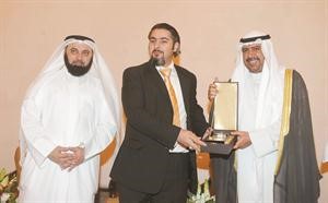 الزميل محمد خليل يتسلم درع الانباء من الشيخ احمد الفهد