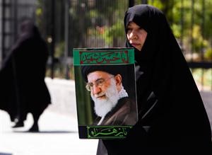 ايرانية تحمل صورة المرشد الاعلى علي خامنئي قبيل حضورها مؤتمرا لدعم المراة البحرينية في طهران امسرويترز﻿