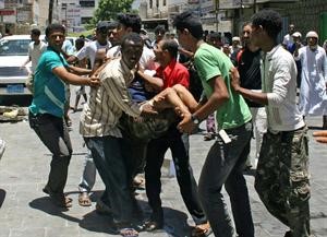 معارضون يمنيون يحملون مصابا في اشتباكات مع الشرطة خلال مظاهرة في عدن امس رويترز