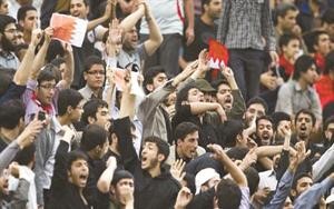 مشجعون ايرانيون يحملون اعلام مملكة البحرين خلال مباراة كرة القدم بين الاتحاد السعودي وبيروزي الايراني في طهران الاثنين الماضي﻿