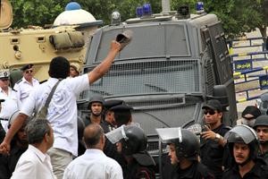 مصري يرفع حذاءه امام سيارة الشرطة التي يستقلها حبيب العادلي بعد الحكم عليه بالسجن 12 عاما افپ