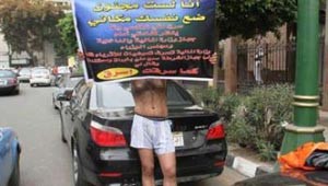 سائق تاكسي يتظاهر بالشورت أمام مجلس الوزراء