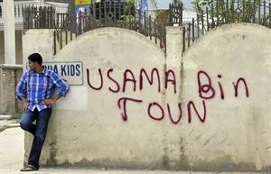 باكستاني يقف بجانب حائط كتب عليه بلدة بن لادن تعبيرا من سكان ابوت اباد عن رغبتهم في تغيير اسم البلدة وفاء لزعيم القاعدة	افپ﻿
