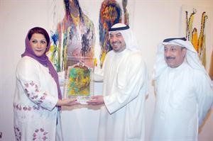 الشيخ طلال الفهديتوسط الدويسان وسلمان خلال تكريمه في المعرض﻿