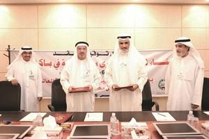 عبدالقادر العجيل ودسليمان شمس الدين يتبادلان وثائق العقد﻿