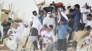 الجماهير تحتمي من المطر بالكراسي﻿