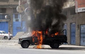 الدخان يتصاعد من سيارة محترقة جراء الاشتباكات بين القوات الحكومية وقوات الاحمر في تعز 	رويترز﻿