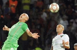 مدافع المغرب بدر القدوري يبعد الكرة خلف مهاجم الجزائر رفيق جبور افپ