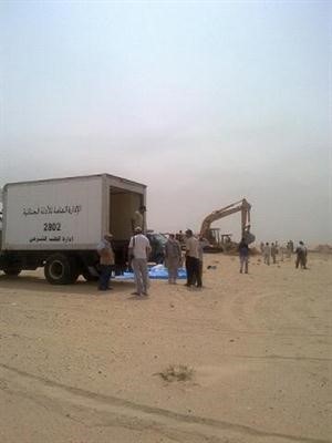 سيارة الادلة الجنائية في موقع المقبرة الجماعية تمهيدا لحمل الرفات﻿
