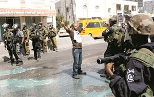 فلسطيني يرفع علامة النصر امام جنود اسرائيليين خلال احياء يوم النكسة في مخيم قلنديا	افپ﻿