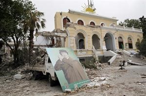 صورة للقذافي بجانب احد المباني الحكومية المدمرة جراء قصف الناتو	روتيرز﻿