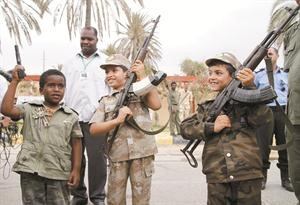 اطفال ليبيون يحملون السلاح قرب طرابلس احتفالا بمرور 41 سنة على تسليم اميركا قاعدة ويلوس الجوية لليبيين والرحيل عن ليبيا 	افپ﻿