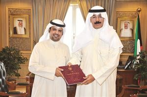 الشيخ محمد الخالد متسلما الكتاب من الزميل محمد المشعان﻿