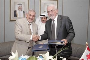 دهلال الساير يتبادل بنود الاتفاقية مع ممثل هيئة كندا للاعتماد ويبدو فيصل الدوسري﻿