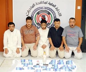 المتهمون الخمسة وامامهم المضبوطات﻿