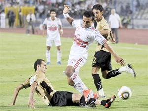 لاعب الزمالك محمد عبدالشافي يحاول المرور من مدافعي طلائع الجيش