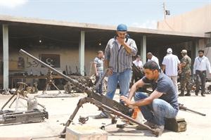 المتطوعون يقومون باصلاح رشاش ثقيل بريطاني الصنع غنموه من كتائب القذافي﻿