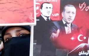 سورية تحمل صورة رجب طيب اردوغان خلال مظاهرة امام السفارة التركية في عمان	رويترز﻿