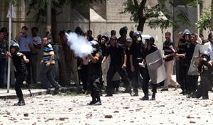 ﻿شرطي يطلق قنبلة مسيلة للدموع خلال الاشتباكات مع المتظاهرين في ميدان التحرير امس 	اپ﻿