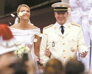 ﻿الامير البرت الثاني والاميرة تشارلين يحييان الحشود خارج القصر بعد حفل الزفاف الديني في موناكو امس 	رويترز﻿