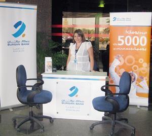 احدى موظفات البنك تعرف بخدماته المصرفية في البورصة
